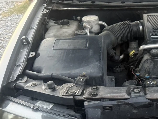 The black plastic air box and intake hose in an engine bay