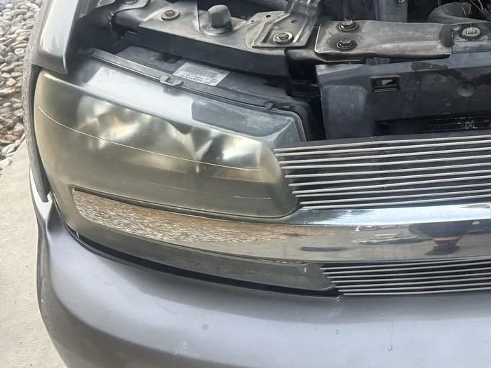 A yellowed, hazy headlight lens on an SUV