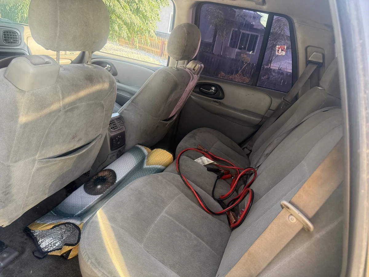 Red and black jumper cables lying on the seat of a car